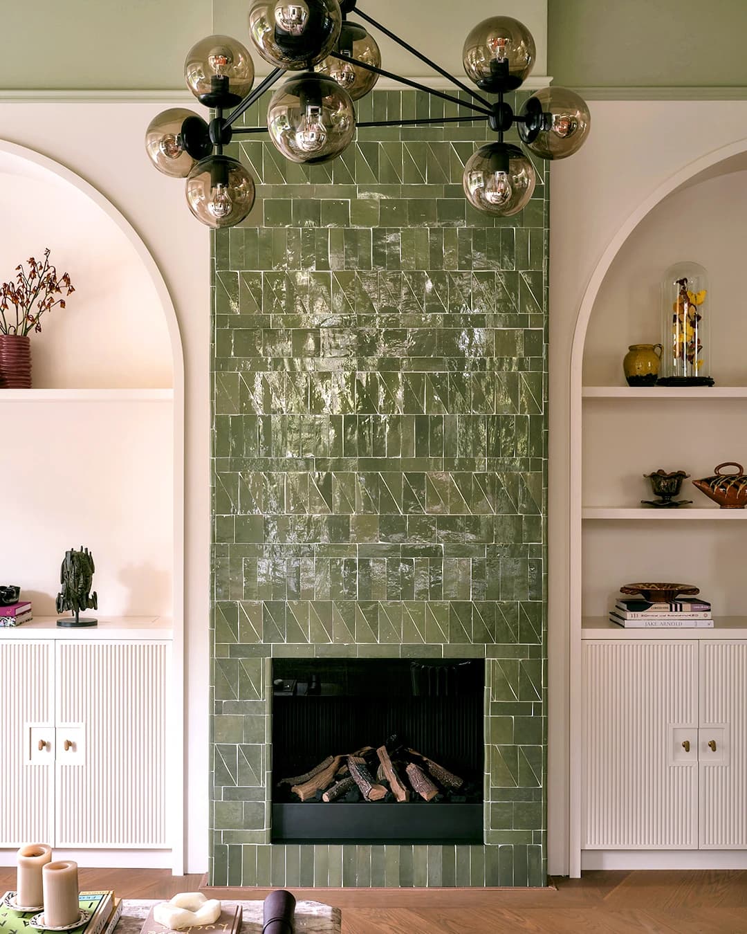 Fireplace surround with green Zellige in triangular and rectangular shapes.